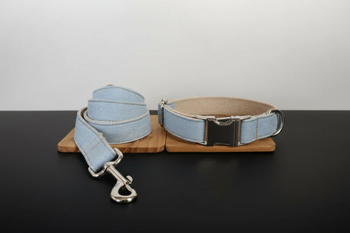 Light blue dog collar and leash set on a wooden stand with a white background